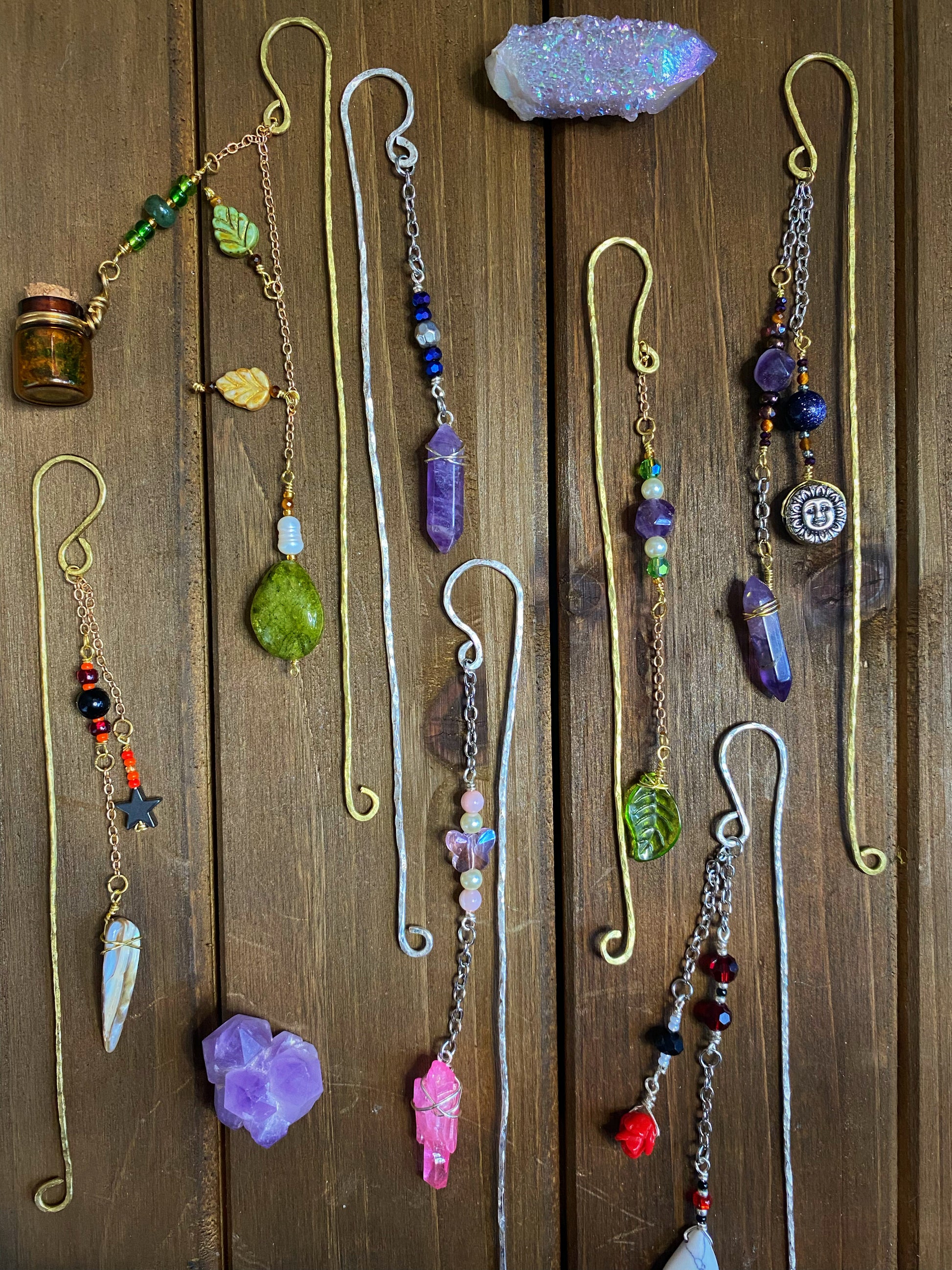 assorted metal beaded bookmarks arranged on a wooden surface