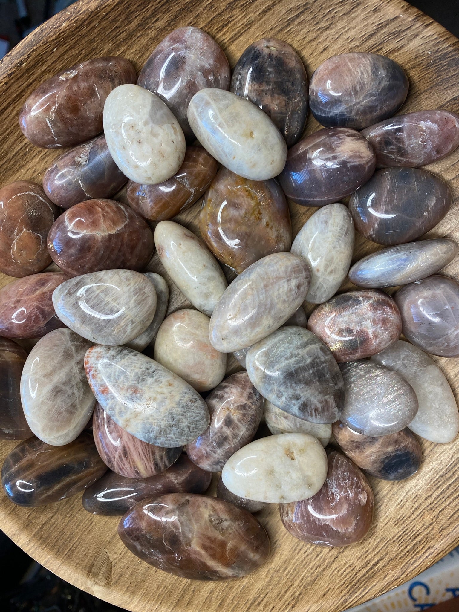 photo of wooden bowl filled with oversized moonstone tumbles