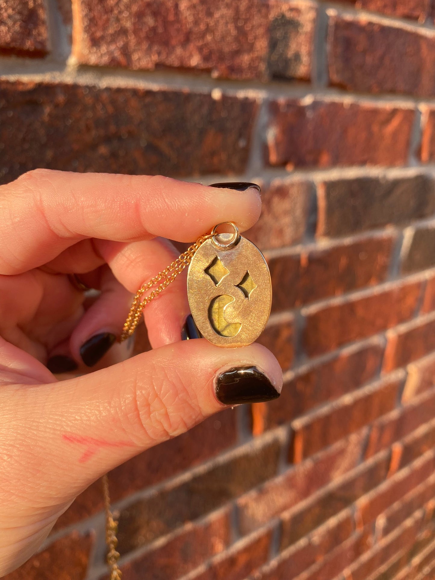 back of carved labradorite pendant with crescent moon and star cutouts